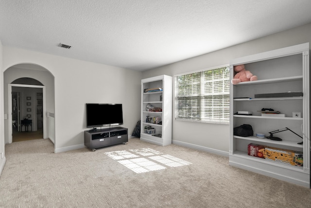 1915 SW Panther Trce, Stuart, FL 34997 - interior space featuring arched walkways, carpet flooring, baseboards, visible vents, and a textured ceiling