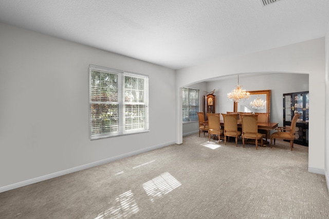 dining space featuring carpet and a notable chandelier