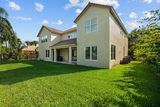 back of house featuring a lawn and central AC