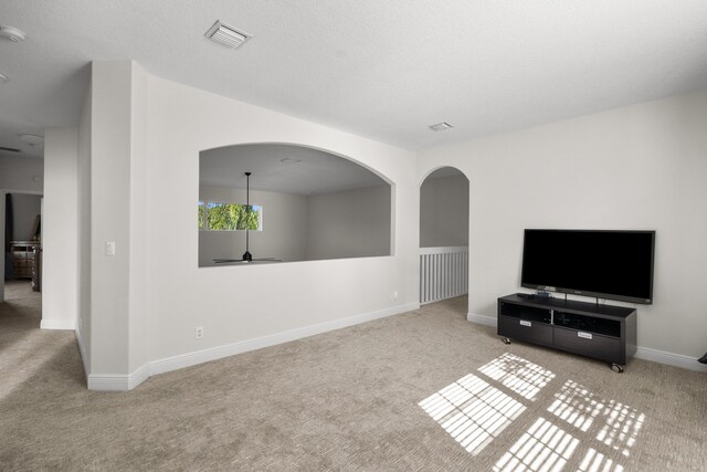 1915 SW Panther Trce, Stuart, FL 34997 - unfurnished living room featuring visible vents, baseboards, and carpet floors