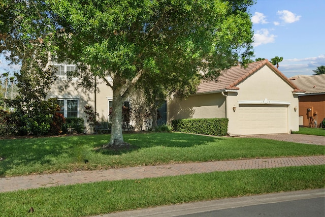 1915 SW Panther Trce, Stuart, FL 34997 - view of property hidden behind natural elements featuring stucco siding, decorative driveway, a tile roof, a front lawn, and an attached garage