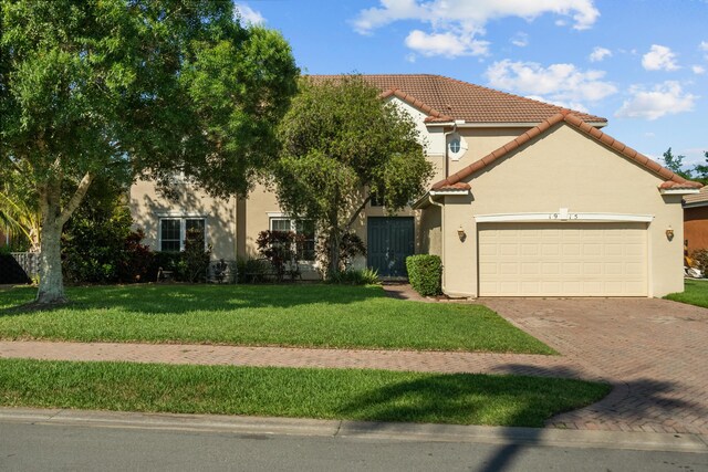 1915 SW Panther Trce, Stuart, FL 34997 - view of front of property with a tiled roof, decorative driveway, a front yard, an attached garage, and stucco siding