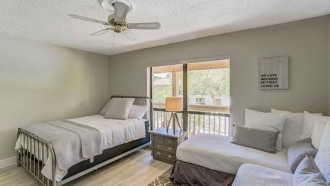 bedroom featuring ceiling fan, a textured ceiling, and light wood-type flooring