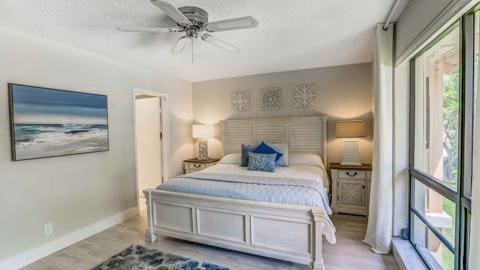 bedroom featuring ceiling fan, a textured ceiling, and light hardwood / wood-style flooring