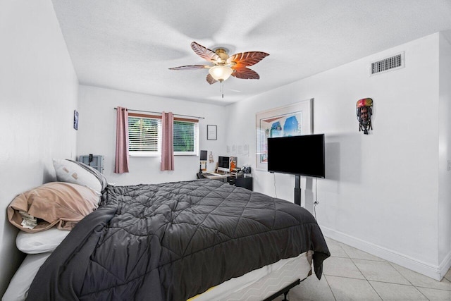 tiled bedroom featuring a textured ceiling and ceiling fan