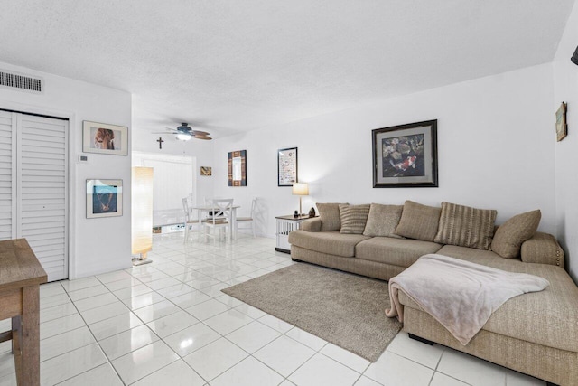 tiled living room featuring a textured ceiling and ceiling fan