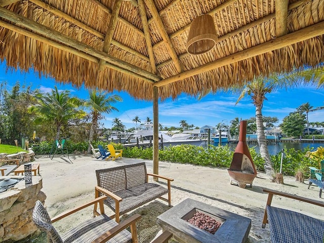 view of patio / terrace with a gazebo, a water view, and an outdoor fire pit