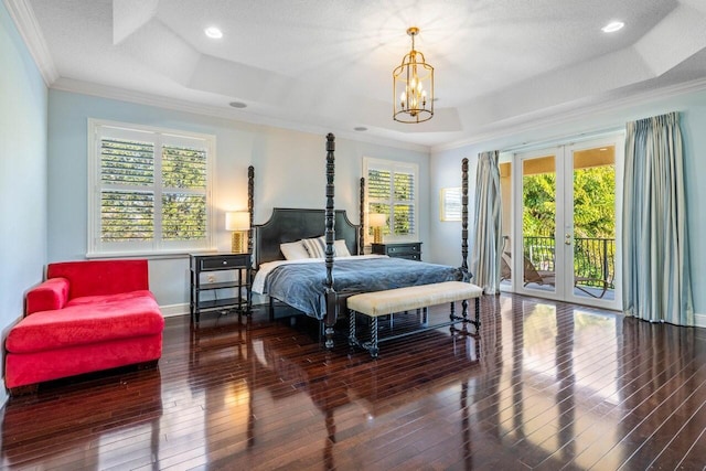 bedroom with access to exterior, a tray ceiling, and ornamental molding