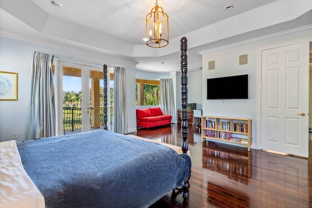 bedroom with access to outside, french doors, a raised ceiling, dark hardwood / wood-style floors, and a notable chandelier