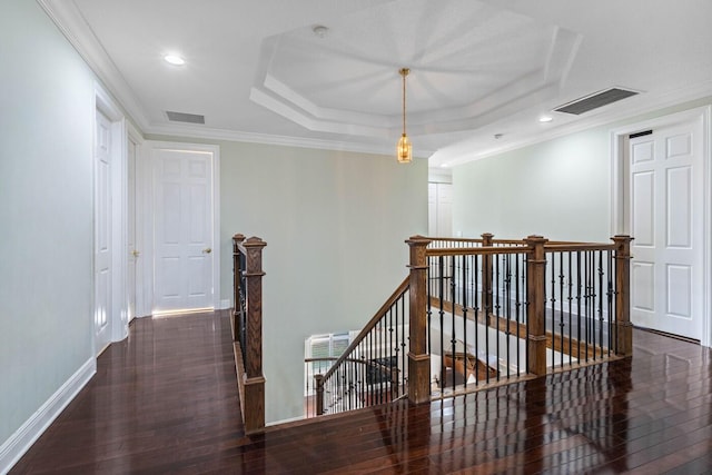 corridor featuring crown molding, dark hardwood / wood-style floors, and a tray ceiling