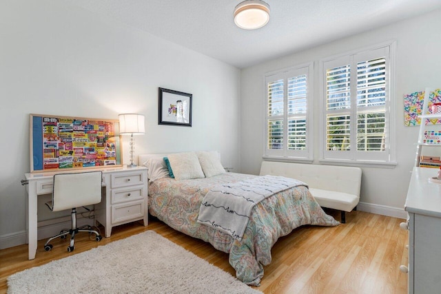 bedroom with light hardwood / wood-style flooring and a textured ceiling