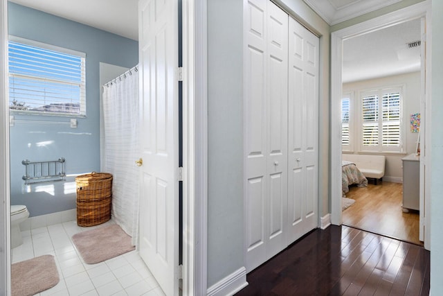 bathroom featuring toilet and crown molding