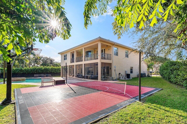 view of sport court with a fenced in pool and a lawn