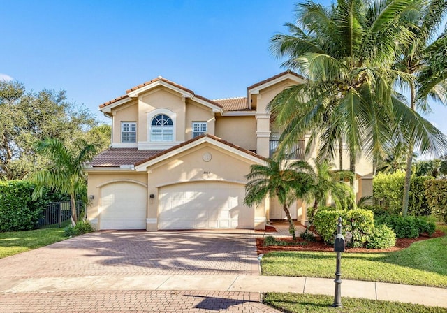 mediterranean / spanish house featuring a garage and a front lawn