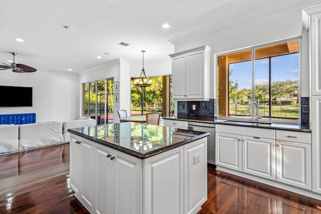 kitchen with sink, white cabinets, stainless steel dishwasher, and a textured ceiling