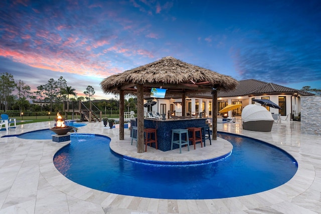 view of pool with a gazebo, exterior bar, a patio area, and a fire pit