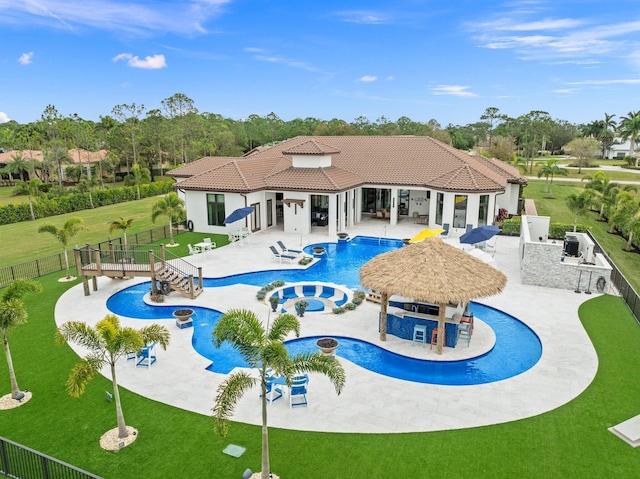 view of swimming pool featuring a yard, a gazebo, a patio area, an outdoor kitchen, and exterior bar