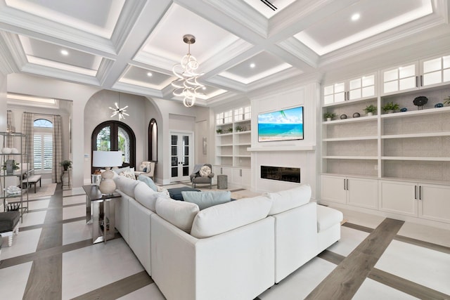 tiled living room with built in features, an inviting chandelier, coffered ceiling, french doors, and beamed ceiling