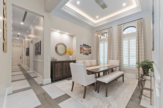 dining area featuring a raised ceiling and light tile patterned floors