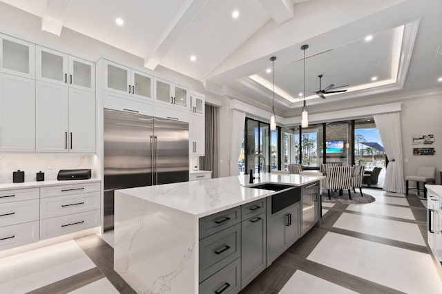 kitchen with stainless steel appliances, sink, a kitchen island with sink, and white cabinets