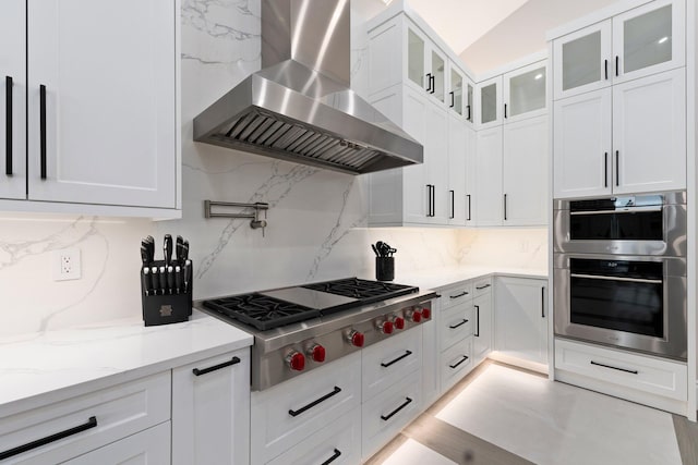 kitchen featuring tasteful backsplash, extractor fan, appliances with stainless steel finishes, and white cabinets