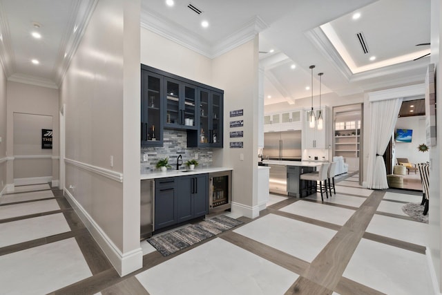 bar with sink, pendant lighting, wine cooler, and backsplash