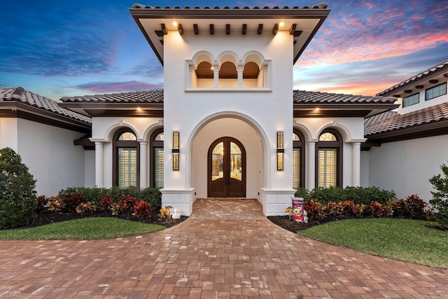 exterior entry at dusk featuring french doors