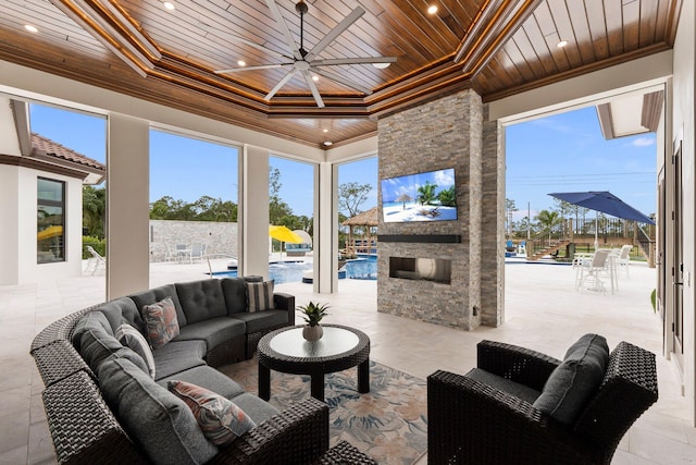 view of patio featuring ceiling fan and an outdoor living space with a fireplace