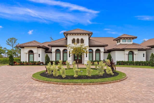 mediterranean / spanish home featuring a front lawn