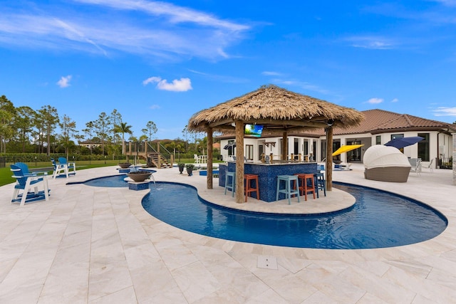 view of swimming pool featuring a patio and an outdoor bar