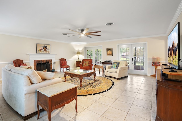 tiled living room featuring ceiling fan, crown molding, french doors, and a fireplace