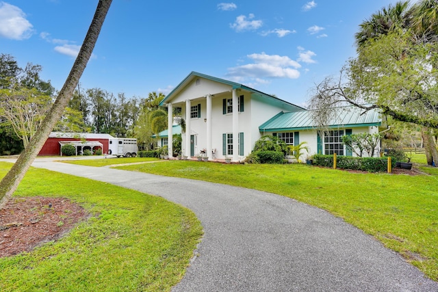 greek revival inspired property with a carport and a front lawn