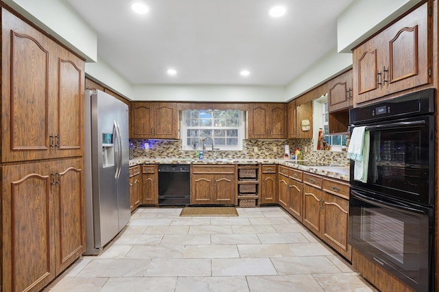 kitchen featuring sink, black appliances, and decorative backsplash