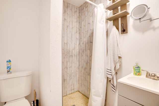 bathroom featuring vanity, toilet, and walk in shower