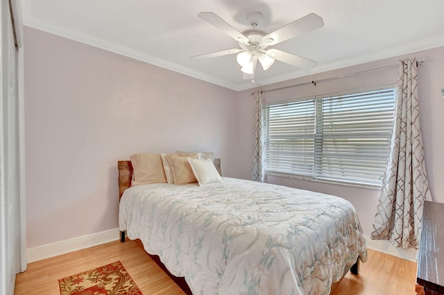 bedroom with hardwood / wood-style floors, ornamental molding, and ceiling fan