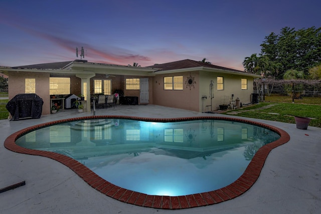 pool at dusk with a patio