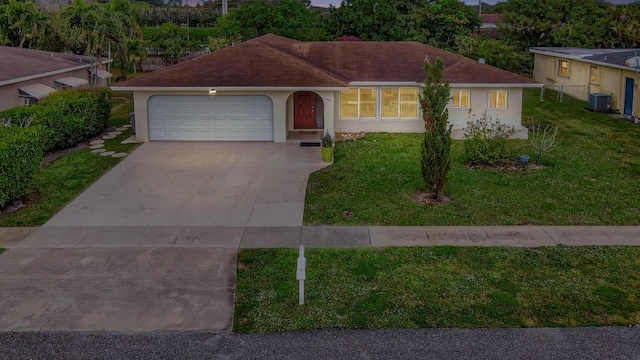 single story home featuring cooling unit, a garage, and a front yard