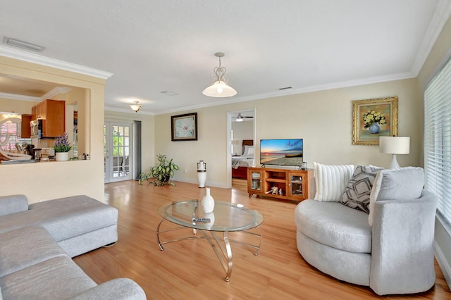 living room with crown molding and light hardwood / wood-style flooring