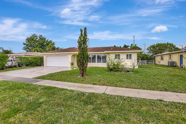 view of front of home with a garage, central AC unit, and a front yard