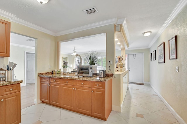 kitchen featuring light stone countertops, light tile patterned floors, and ornamental molding