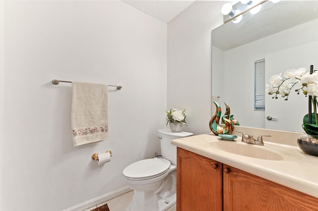 bathroom featuring tile patterned floors, toilet, and vanity