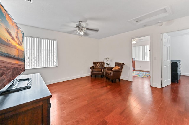 sitting room with dark wood-type flooring, ceiling fan, and plenty of natural light