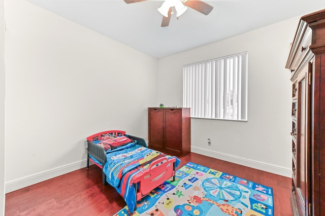 bedroom with dark hardwood / wood-style flooring and ceiling fan