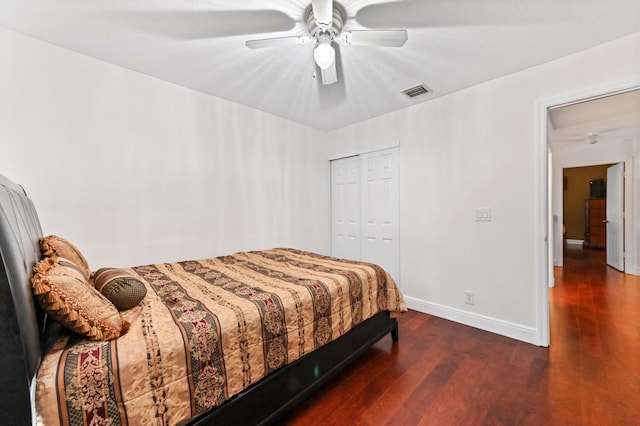 bedroom featuring dark wood-type flooring, a closet, and ceiling fan