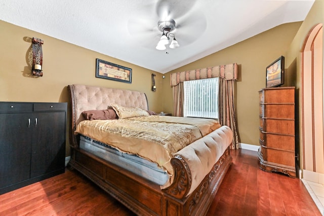 bedroom with dark hardwood / wood-style flooring, lofted ceiling, and ceiling fan