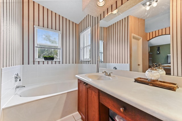 bathroom featuring tile patterned flooring, a bathing tub, and vanity