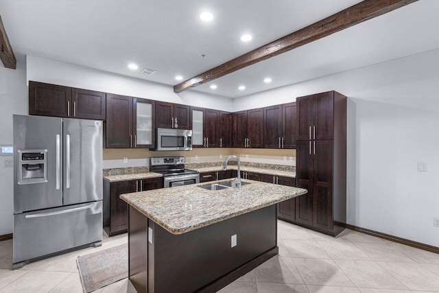 kitchen with appliances with stainless steel finishes, sink, beam ceiling, a center island with sink, and a breakfast bar area