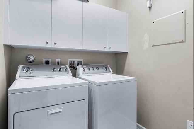 washroom with cabinets and washing machine and clothes dryer