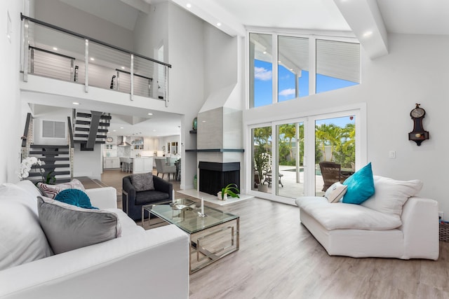 living room with light wood-type flooring and a high ceiling