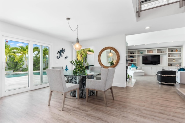 dining area with built in shelves and light wood-type flooring